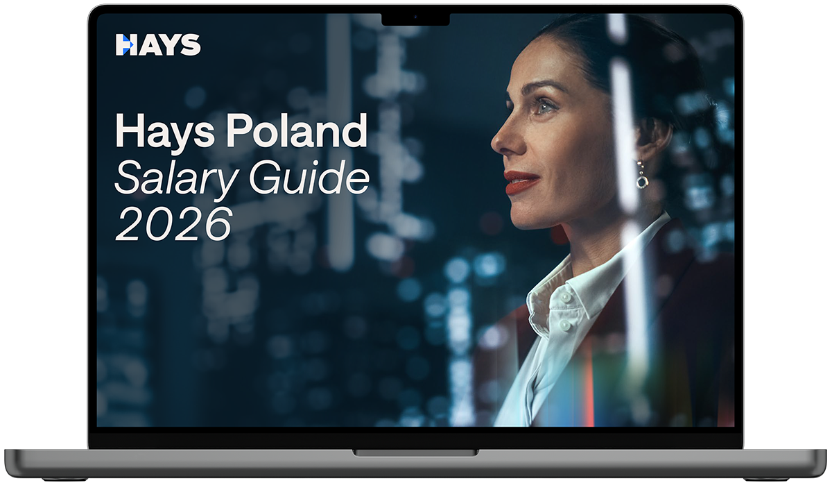 Laptop screen displaying the Hays Belgium Salary Guide 2026 cover, featuring text on a blue background with a person in business attire in the foreground and others in the background.