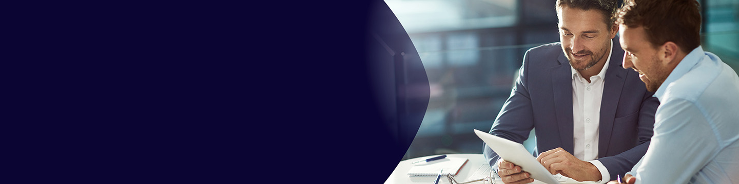 Colleagues discussing insights on a tablet while seated on colorful lounge chairs in an open workspace.